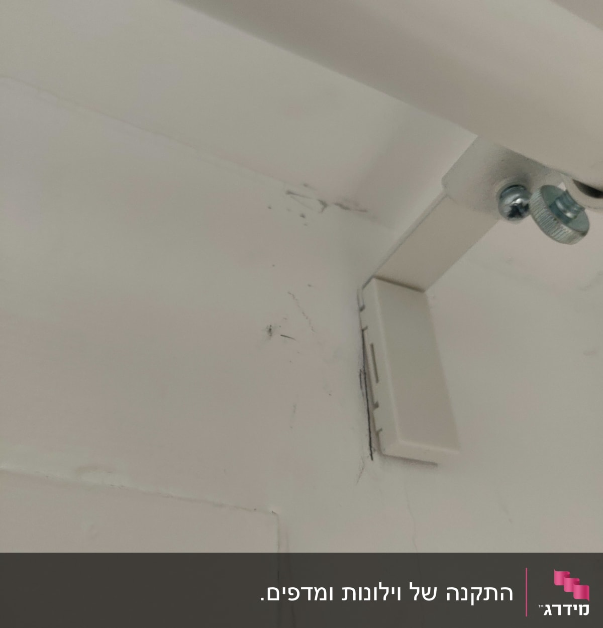 תושבת מתכת עם ברגים על קיר לבן